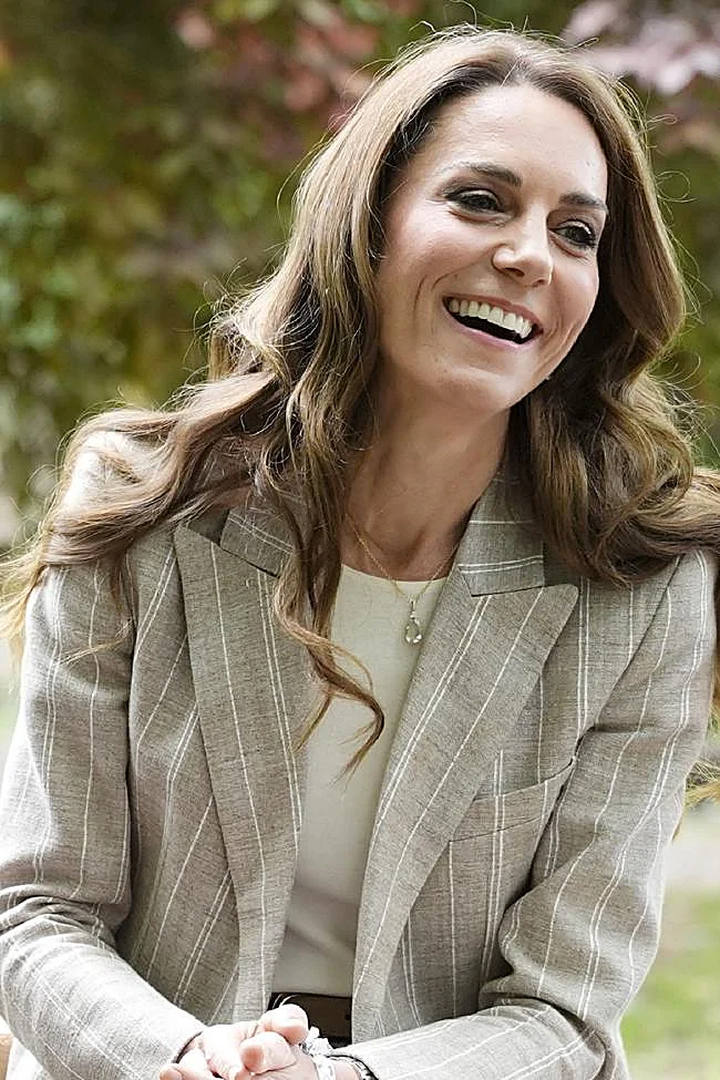 Kate Middleton aux cheveux méchés et ondulés.