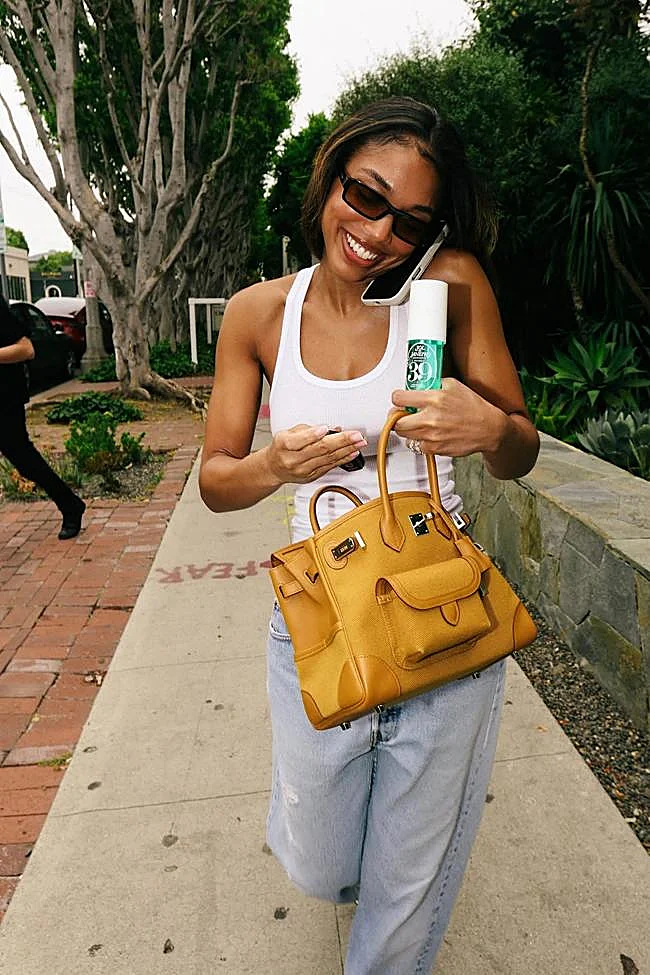 Lori Harvey avec l'une des brumes signature de Sol de Janeiro.
